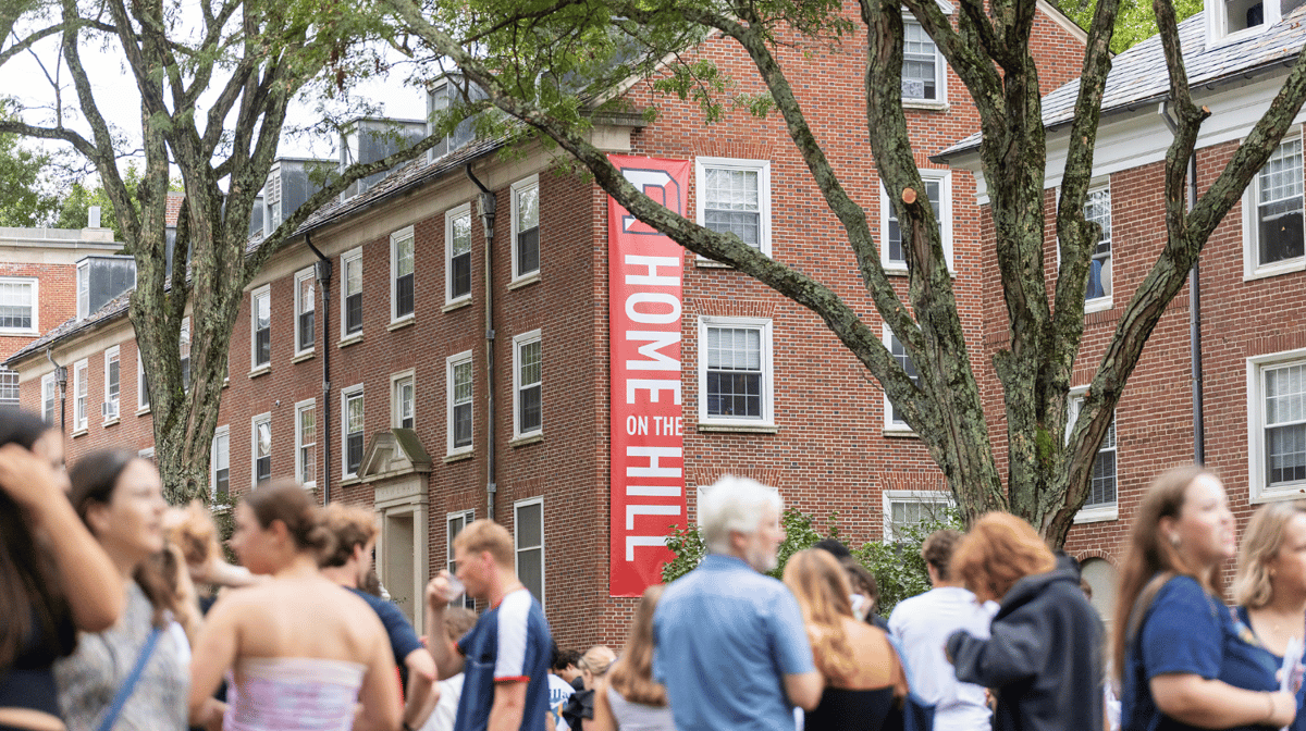 A photo of a Home on The Hill banner hanging on a brick residence hall.